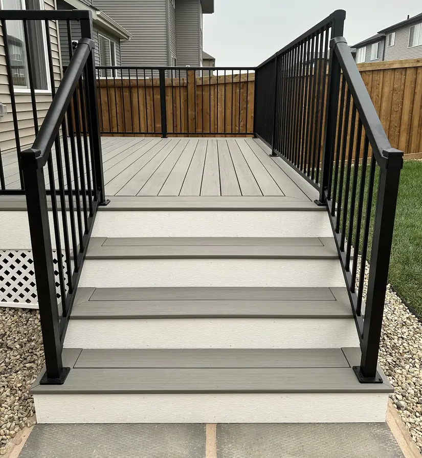 Composite stair treads with white risers and black aluminum railing, Edmonton — TrueBlue Builders